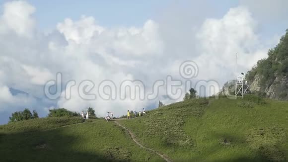 鸟瞰游客站在山顶风景如画蓝天白云视频的预览图