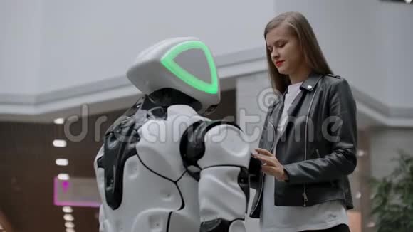 与机器人接触的快乐女人点击机器人屏幕机器人和女人互动视频的预览图