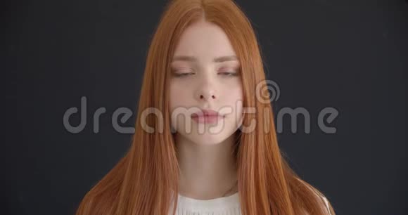 在黑色背景下美丽的姜模型的特写肖像冷静地进入相机视频的预览图