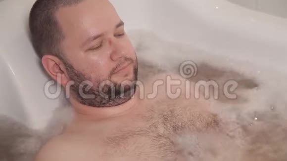 这个人躺在一个热疗浴中用水按摩水疗酒店视频的预览图
