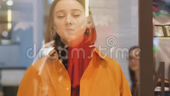 商店橱窗附近穿着时髦衣服的年轻女子视频的预览图