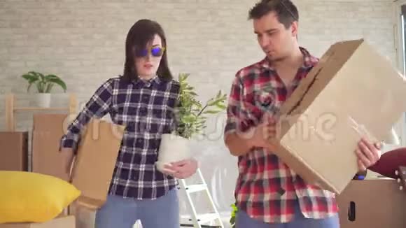 一对快乐的年轻夫妇走进新房子手里拿着盒子跳舞玩得很开心视频的预览图