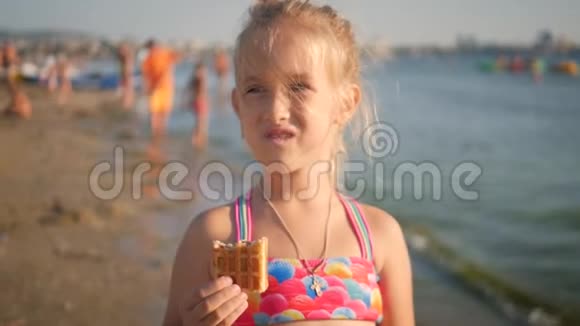 小女孩在海滩上吃饼干视频的预览图