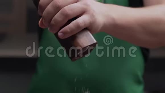 宏观镜头厨师用盐磨为他的饭加了一些盐盐慢慢地落下用盐磨视频的预览图