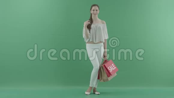 年轻女性顾客在虚拟商店购买绿色屏幕上有袋子视频的预览图