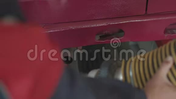 一个服务站工作人员在汽车的排气管上放一根管子来测量烟雾和废气视频的预览图