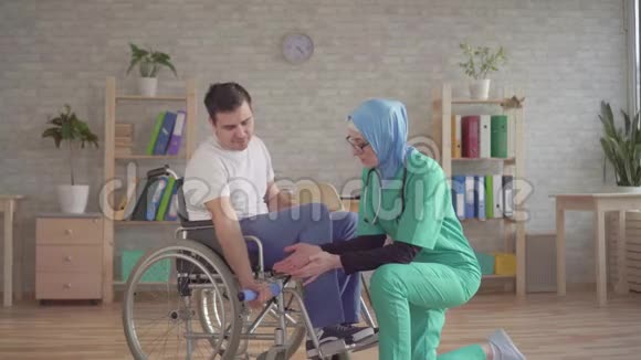 戴头巾的穆斯林护士帮助轮椅残疾人康复视频的预览图