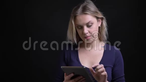 女商人打开平板电脑中的应用程序并在黑色背景下将其显示为相机的绿色屏幕视频的预览图