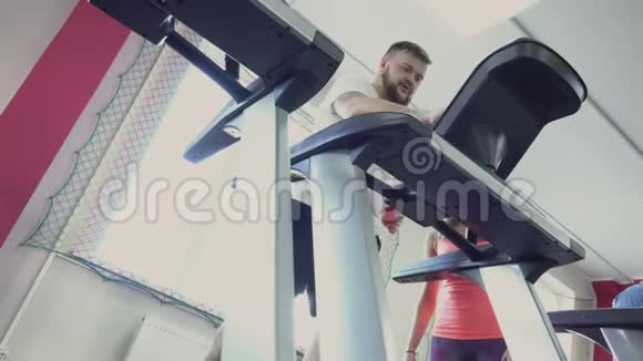 他在健身俱乐部跑步减肥演习从个人教练为胖子健康和健身房视频的预览图