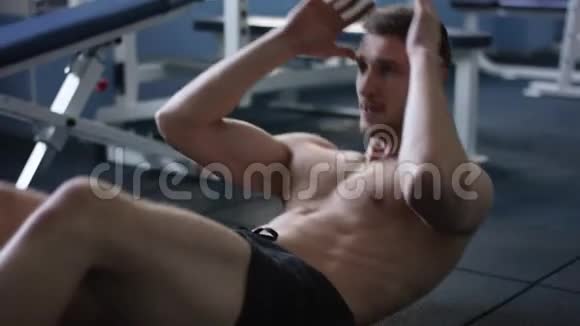 成人运动员在体育馆里裸着身体做仰卧起坐视频的预览图