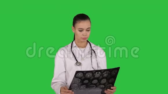 女医生带白色标签看x射线摄影图像ct扫描绿色屏幕上的MRIChroma键视频的预览图