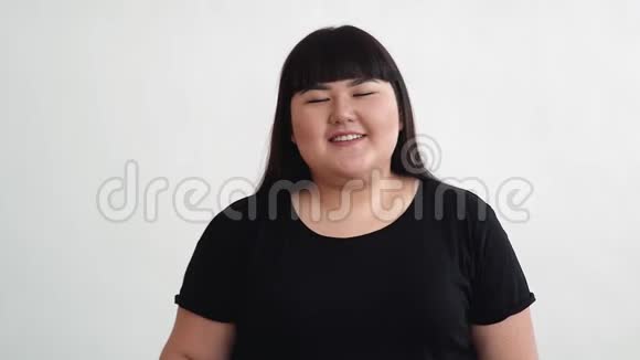 一个丰满的亚洲女孩带着一个汉堡到她的脸上是惊讶嗅和微笑视频的预览图