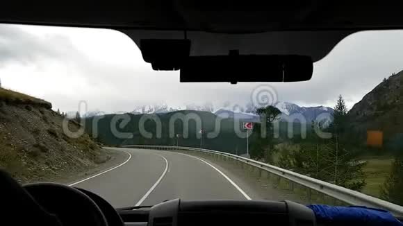 从汽车的前窗上看到一条美丽蜿蜒的山路乘车穿越荒野交通旅行视频的预览图