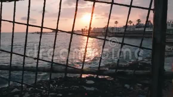 美丽的日落穿过格子旅游区的粉红色日落海岸日落日落时的长廊行人观光区视频的预览图