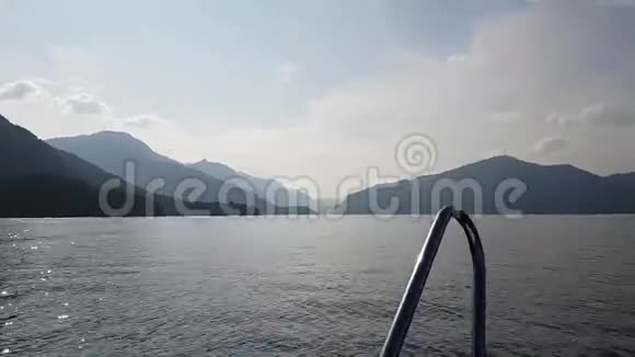 从摩托艇上快速向岸边的方向漂浮在湖面上霾中岸边美景视频的预览图