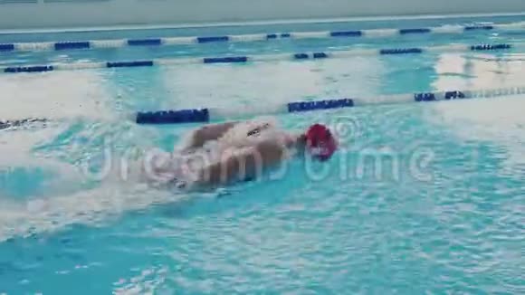 强壮灵活运动的年轻女子游泳与蝴蝶风格的游泳池慢动作很多气泡和喷雾视频的预览图