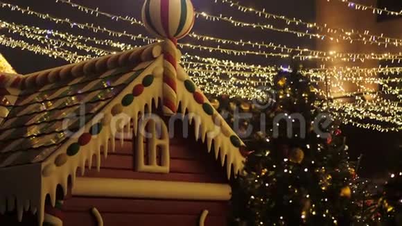 在圣诞节姜饼屋矗立在圣诞树附近的街道上视频的预览图