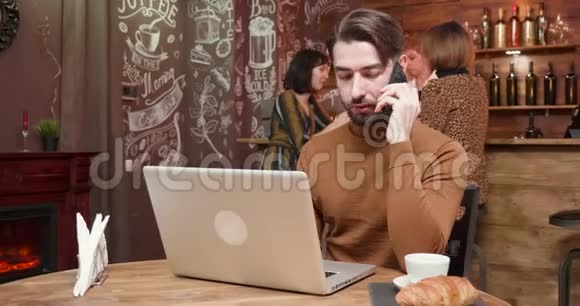 一个男人在一家老式咖啡店里打电话视频的预览图