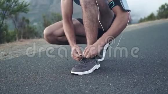 一名年轻的白种人男性跑步者在跑步前把鞋系好站起来看风景视频的预览图