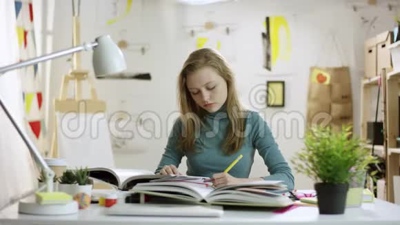 年轻时精疲力竭的女学生读书做家庭作业而其他人则给她带来其他书视频的预览图
