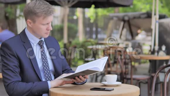 户外坐着的商人读书视频的预览图