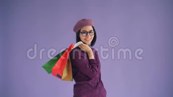 戴着眼镜戴着时尚帽子手提购物袋的幸福年轻女士画像视频的预览图