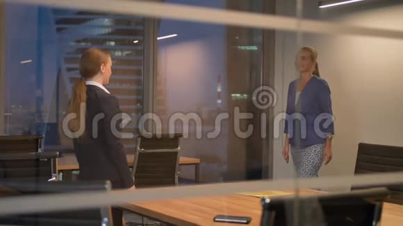 两名女雇员同事在现代办公室握手视频的预览图