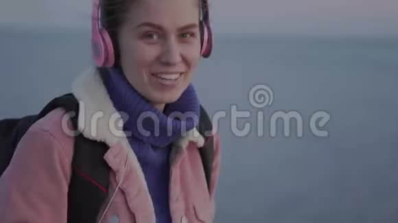 一个女孩微笑着站在海边手里拿着一台老式相机视频的预览图