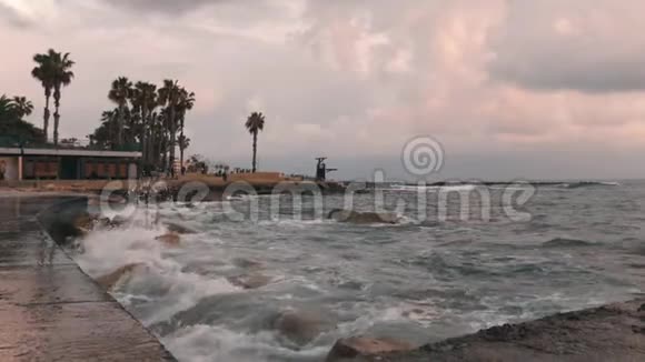 近景城市海滩暴风雨天气下的城市海滩有暴风雨长廊的旅游区巨大的海浪拍打在石头上视频的预览图