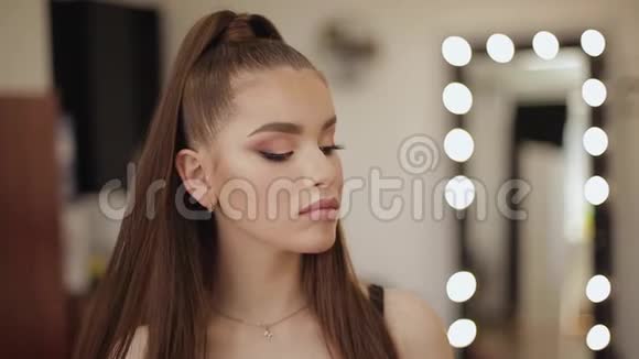 在美容院化妆的年轻漂亮女人的肖像晚上化妆光的背景视频的预览图