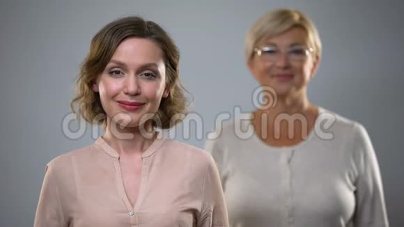 美丽的女性在镜头前微笑年长的女士在背后安全和健康的衰老视频的预览图