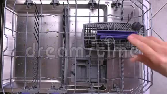 男人手在洗碗机篮子里放一个白色的脏盘子和餐具然后把它推到里面视频的预览图