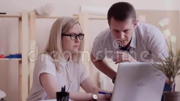 白种人的女孩戴着眼镜坐在办公室在笔记本电脑上工作然后开始征求意见视频的预览图