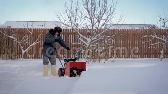 人在雪后的道路上清扫积雪在家中白雪皑皑视频的预览图