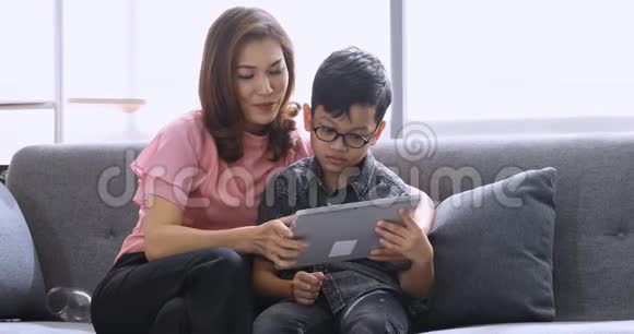 妈妈和儿子在客厅里用平板电脑视频的预览图