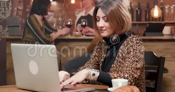 女企业家在咖啡店工作时在笔记本电脑上打字视频的预览图