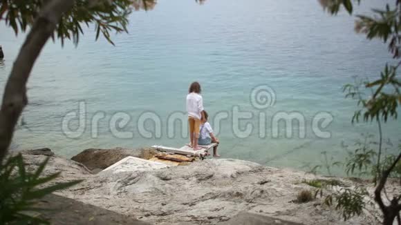 一对小学生一男一女坐在海边暑假异国度假视频的预览图