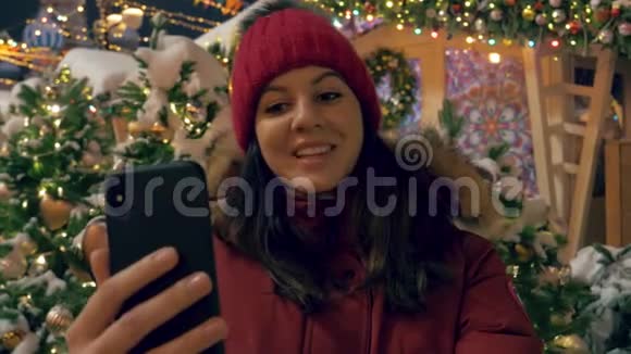 幸福的女人在智能手机背景下选择装饰圣诞树视频的预览图