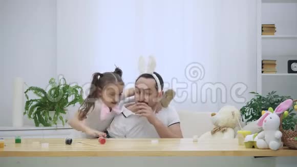 快乐而开朗的女儿正试图爬上父亲的肩膀跳舞父亲坐在木头下面视频的预览图