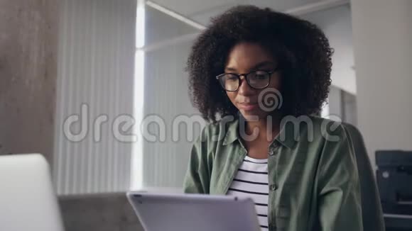 年轻的女商人用数码平板电脑看相机视频的预览图