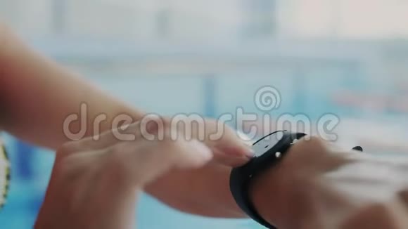 特写镜头女人用她的防水智能手表与触摸屏标记时间她为健身手环设置计时器视频的预览图