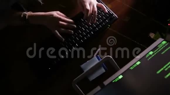 女人的手在黑暗的房间里输入电脑代码黑客攻击电脑黑客工作中的程序员视频的预览图