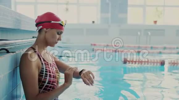 活跃的运动女性使用她的防水智能手表与触摸屏标记时间在游泳池她穿上了视频的预览图