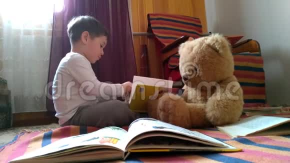 可爱的小男孩在家看书和玩具熊玩具聊天有趣的讲座视频的预览图