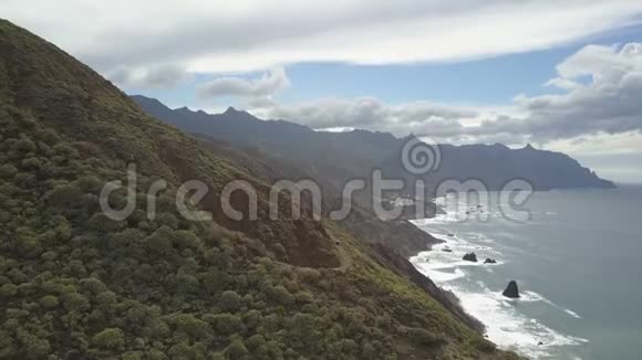 鸟瞰美丽的热带景观海岸线森林覆盖的山脉和戏剧性的云层初步看法视频的预览图