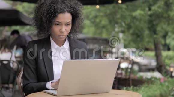 非洲妇女坐在户外咖啡厅的视频聊天视频的预览图