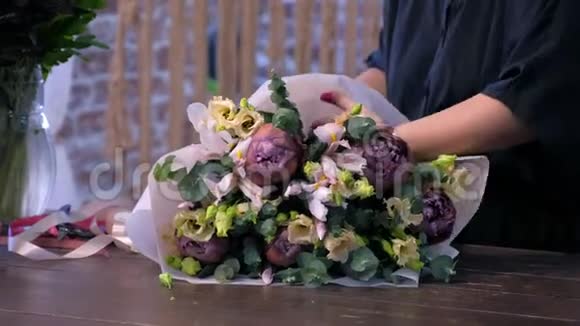 花商妇女在花店里做大花束和丝带的领带茎视频的预览图
