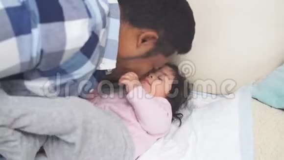 父亲亲吻6个月大的白色背景的微笑女婴视频的预览图