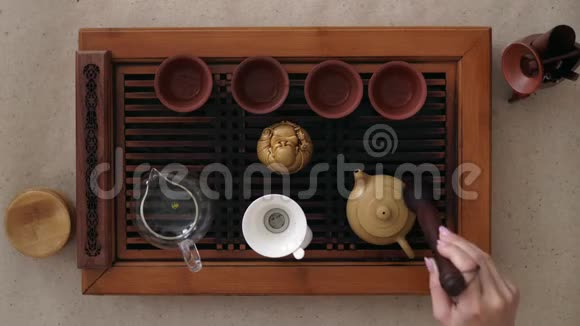 中国茶道姑娘的手壶上轻轻地握着一支特制的刷子视频的预览图