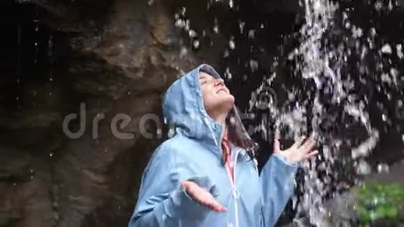 年轻开朗的女人的手臂伸出在壮观的瀑布后面年轻女子用威严的手臂伸出视频的预览图